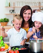Vegetarische Ernährung - Mutter kocht mit Kindern